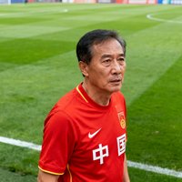 一位中年男性球迷头像，穿着中国国家队球衣，背景是足球场草坪